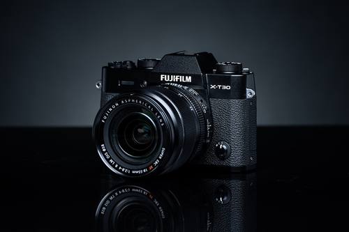 Fujifilm X-T30 II с зум-объективом на тёмном фоне