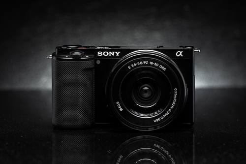 Sony ZV-E10 с китовым объективом 16–50 мм на тёмном фоне