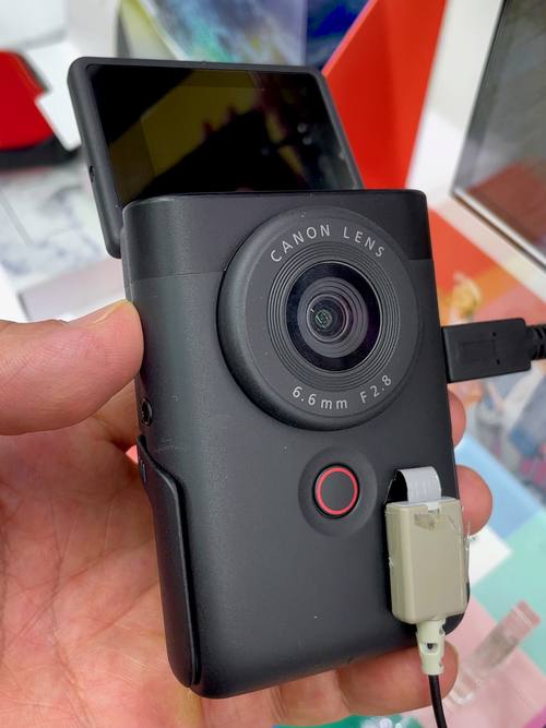 Canon PowerShot V10 в руке, экран откинут вверх