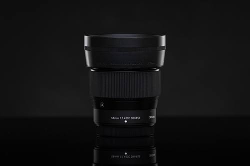 Объектив Sigma 56mm F1.4 DC DN Contemporary с блендой на тёмном фоне