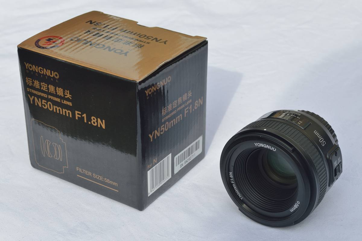 Объектив Yongnuo YN50mm F1.8N рядом с коробкой