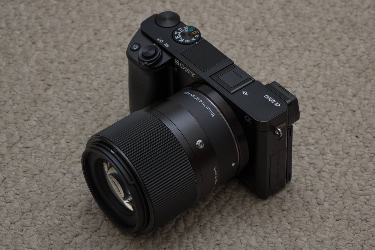 Камера Sony a6000 с объективом Sigma 30mm F1.4 на ковре
